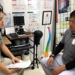 くすの樹接骨院町田店で施術を受ける男性患者がインタビューをうけている様子